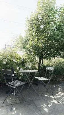 a table and two chairs sitting next to a tree at Luxury spacious private loft, between city & beach in Heemstede