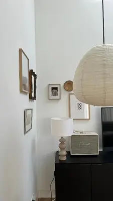 a lamp on a dresser with a clock and pictures at Luxury spacious private loft, between city & beach in Heemstede