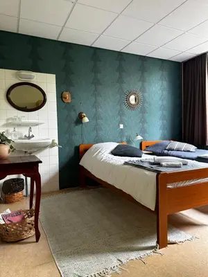 a bedroom with a bed and a sink at Het Huis van Bewustzijn in Limmen