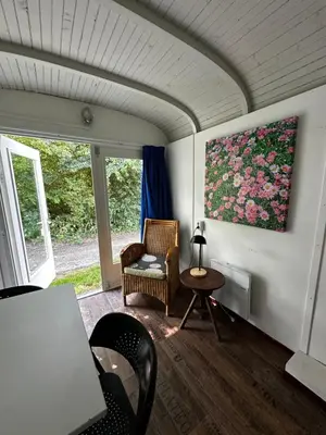 a living room with a chair and a painting on the wall at Het Huis van Bewustzijn in Limmen