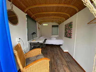 a room with a bed and a table and chairs at Het Huis van Bewustzijn in Limmen