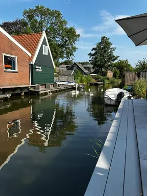 a view of a river with a house and a boat at Pakhuis Prins in Zaandam