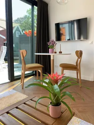 a living room with a table and two chairs and a plant at Pakhuis Prins in Zaandam