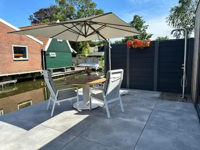 a table and chairs with an umbrella on a patio at Pakhuis Prins in Zaandam