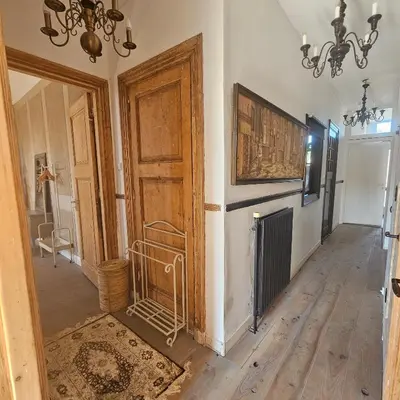 a hallway with a wooden door and a chandelier at B&B Boskoop in Boskoop