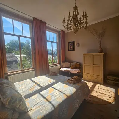 a bedroom with a large bed and a large window at B&B Boskoop in Boskoop