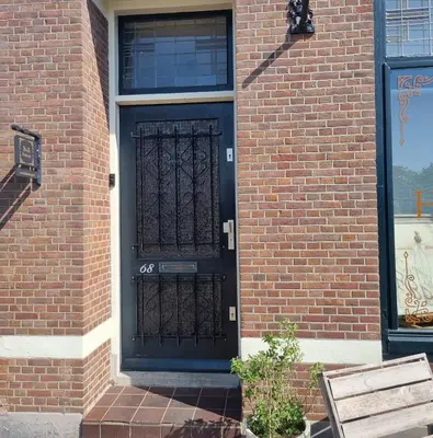 a black door on the side of a brick building at B&B Boskoop in Boskoop