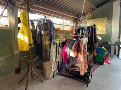a clothing store with a rack of clothes at Vintage caravan in old orchard at farm Huize Blokland in Hem