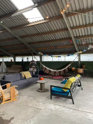 a living room with a couch and chairs in a tent at Vintage caravan in old orchard at farm Huize Blokland in Hem