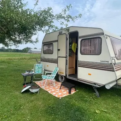 Vintage caravan in old orchard at farm Huize Blokland