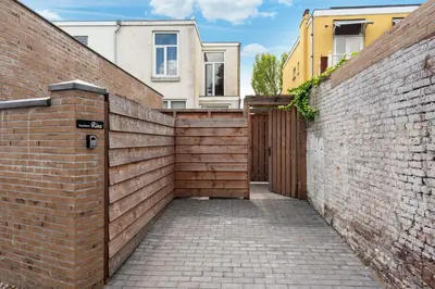 a wooden gate in a brick wall next to a building at Beachhouse Rina - Free Parking in Zandvoort