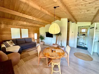 a living room with a table and a couch at Mediterranean style chalet with jacuzzi and garden near Amsterdam in Vijfhuizen