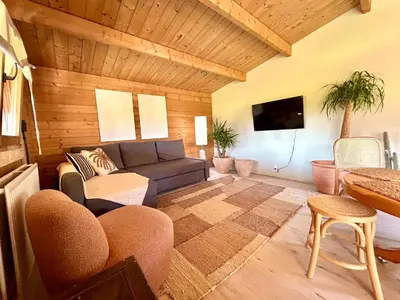 a living room with a couch and a table at Mediterranean style chalet with jacuzzi and garden near Amsterdam in Vijfhuizen