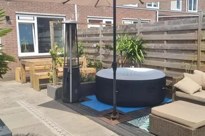 a hot tub and an umbrella on a patio at Garden, Jacuzzi, bbq, city centre, 2 bedrooms in Alkmaar