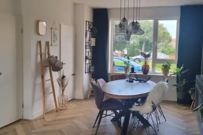 a dining room with a table and chairs and a window at Garden, Jacuzzi, bbq, city centre, 2 bedrooms in Alkmaar