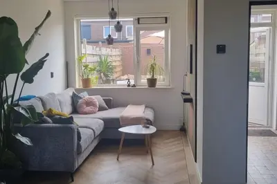 a living room with a couch and a table at Garden, Jacuzzi, bbq, city centre, 2 bedrooms in Alkmaar