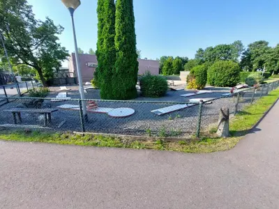 a fence with a park with a bench and trees at Ferienhaus Holland in Opmeer