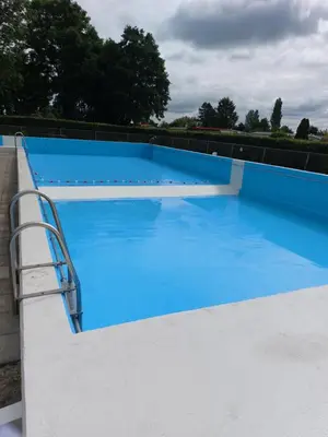 a large blue swimming pool with a metal rail at Ferienhaus Holland in Opmeer