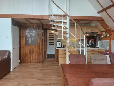 a living room with a staircase and a kitchen at Ferienhaus Holland in Opmeer