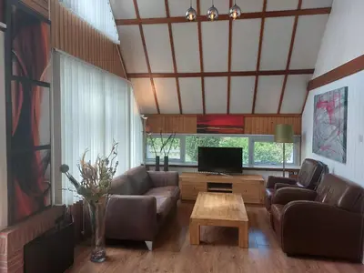 a living room with couches and a tv and a table at Ferienhaus Holland in Opmeer