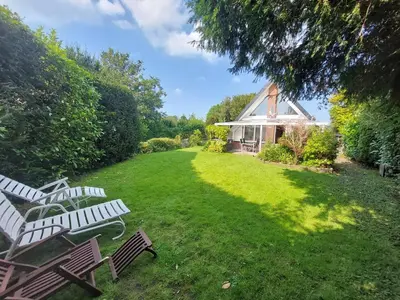 a group of chairs in a yard with a house at Ferienhaus Holland in Opmeer