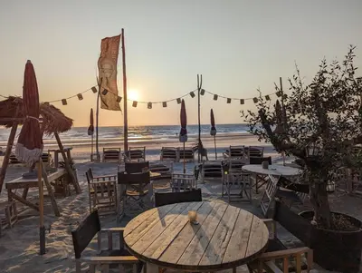 a cafe on the beach with tables and chairs at Casa Zandvoort in Bentveld