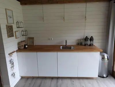 a kitchen with white cabinets and a sink at Casa Zandvoort in Bentveld