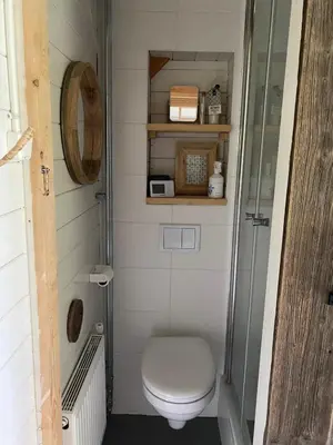 a small bathroom with a toilet and a shower at Casa Zandvoort in Bentveld