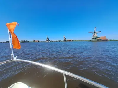 a boat in the water with windmills in the background at B&B Teddy 