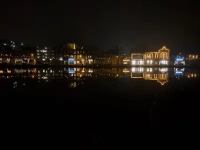 a night view of a lit up building next to a body of water at B&B Teddy 