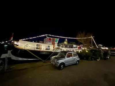 a small car parked next to a boat at night at B&B Teddy 