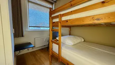 a bedroom with two bunk beds and a window at Strand Panorama Egmond in Egmond aan Zee