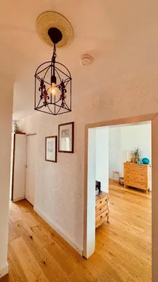 a living room with a chandelier and a wooden floor at Strand Panorama Egmond in Egmond aan Zee