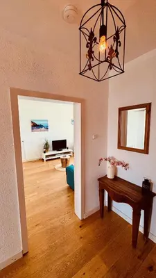 a living room with a table and a chandelier at Strand Panorama Egmond in Egmond aan Zee