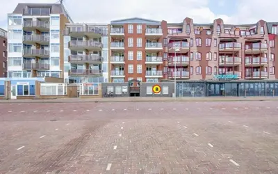 an empty street in front of a large building at Studio B in Egmond aan Zee