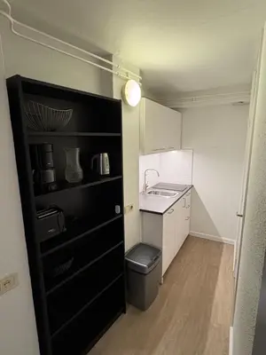 a small kitchen with a sink and a black cabinet at Studio B in Egmond aan Zee