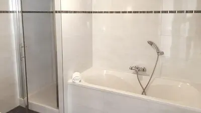 a bathroom with a bath tub and a shower at Dutchen Park Weideduyn in Schoorl