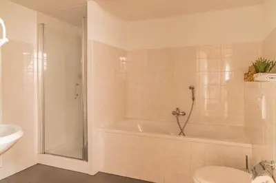 a bathroom with a tub and a toilet and a sink at Dutchen Park Weideduyn in Schoorl