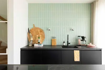a kitchen with a black counter and a sink at Villa Amsterdam Castle in Muiden