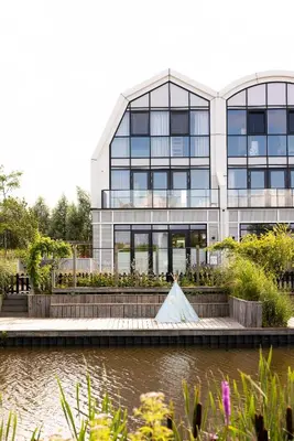 a building with a tent in front of a river at Villa Amsterdam Castle in Muiden
