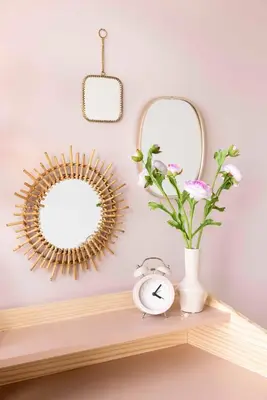 two mirrors on a shelf with a clock and a vase with flowers at Villa Amsterdam Castle in Muiden
