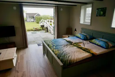 a bedroom with a large bed and a large window at B&B De groene loper in Sint Pancras