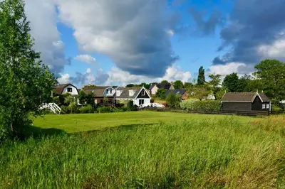 a group of houses in a green field at B&B De groene loper in Sint Pancras