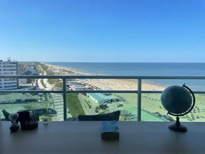 a desk with a view of a beach and the ocean at Beach Loft in Zandvoort