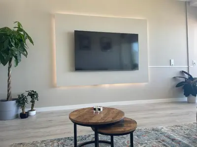 a living room with a table and a tv at Beach Loft in Zandvoort