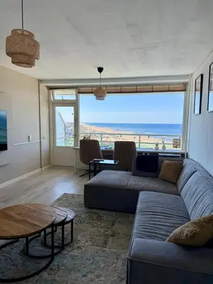 a living room with a couch and a view of the ocean at Beach Loft in Zandvoort