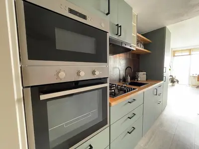 a kitchen with a stainless steel oven and cabinets at Beach Loft in Zandvoort