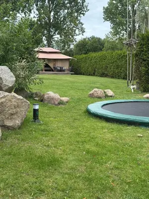 a pool in a yard with rocks and a house at Back to Basic in Zwaanshoek