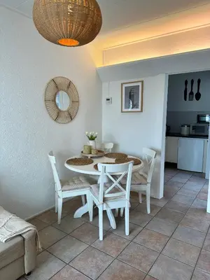 a dining room with a white table and chairs at Cosy Home Zandvoort in Zandvoort