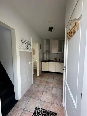 a kitchen with a door and a tile floor at Cosy Home Zandvoort in Zandvoort